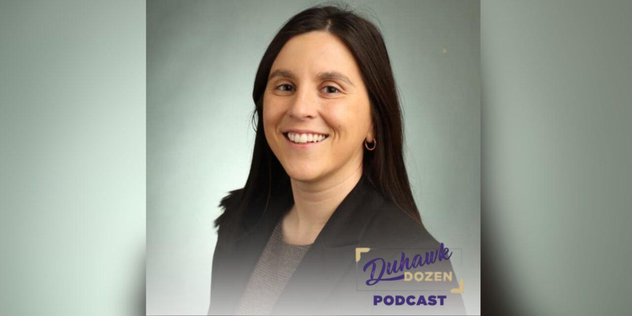 smiling woman with black hair and gray background