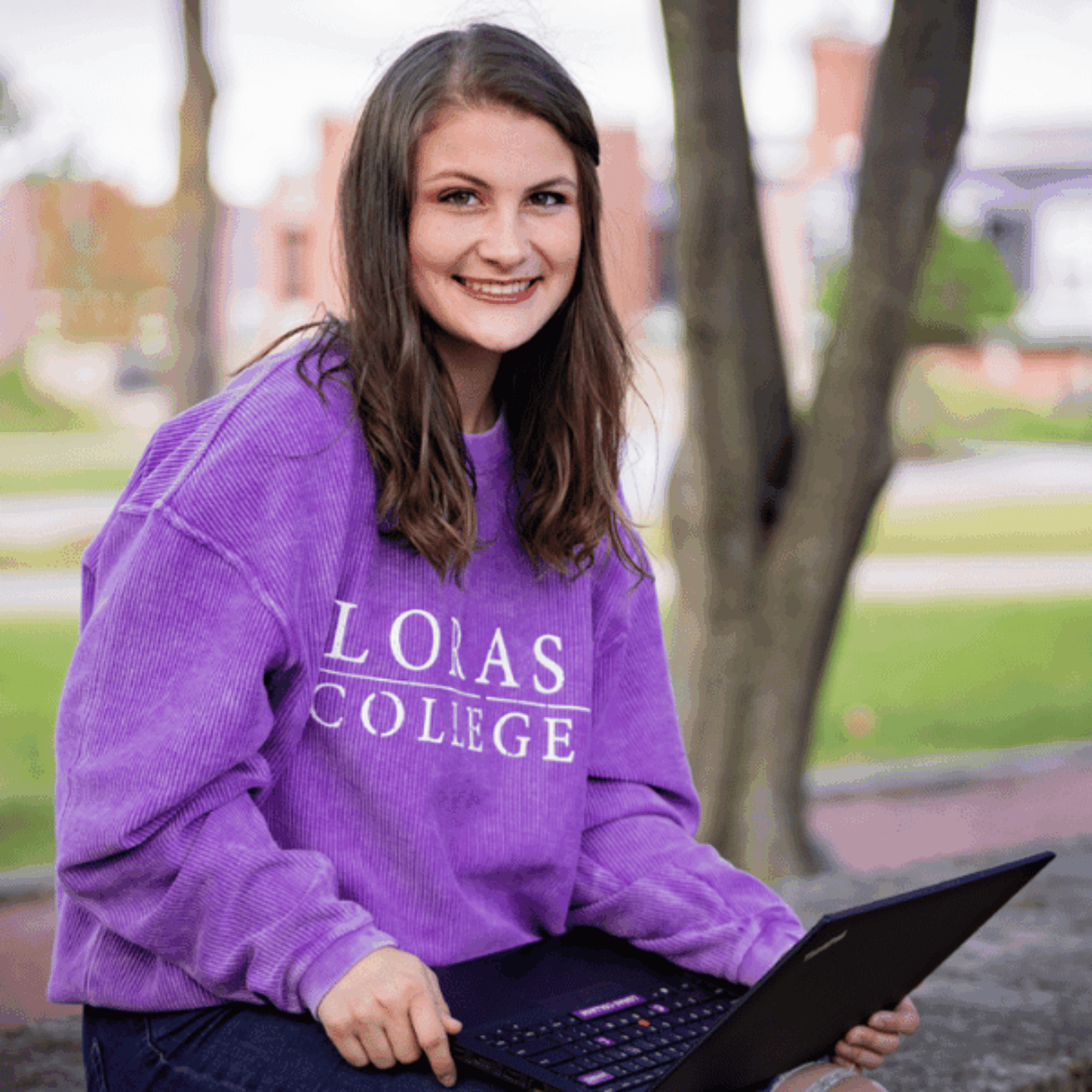 student sitting on rocks central campus