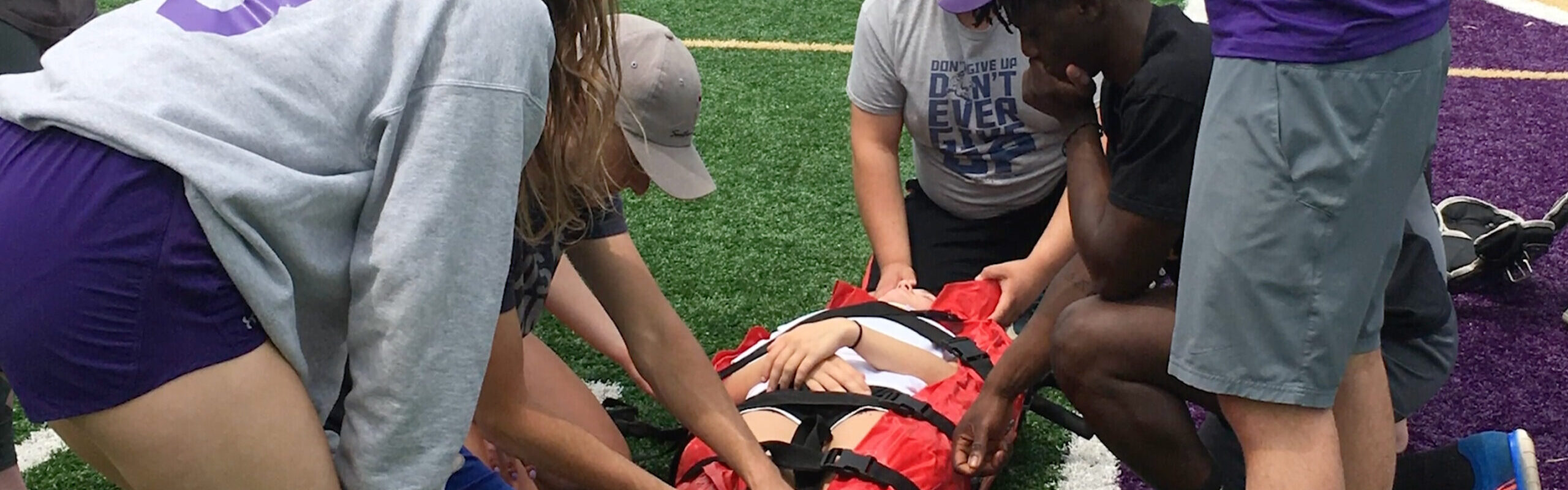 Loras College Athletic Training students carrying injured student off soccer field