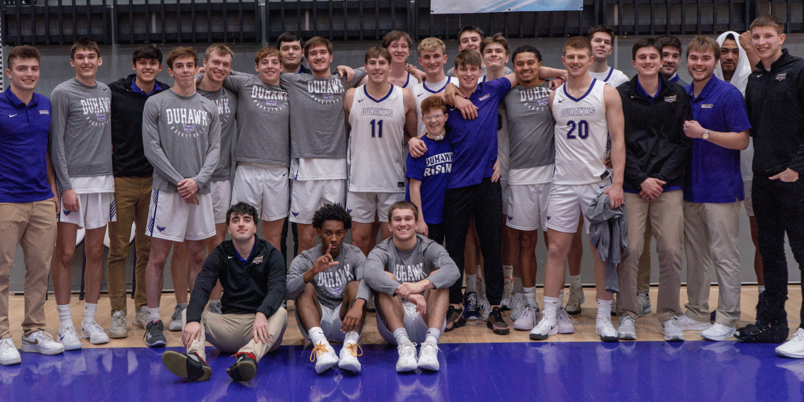 Men's Basketball team posing with kid captain