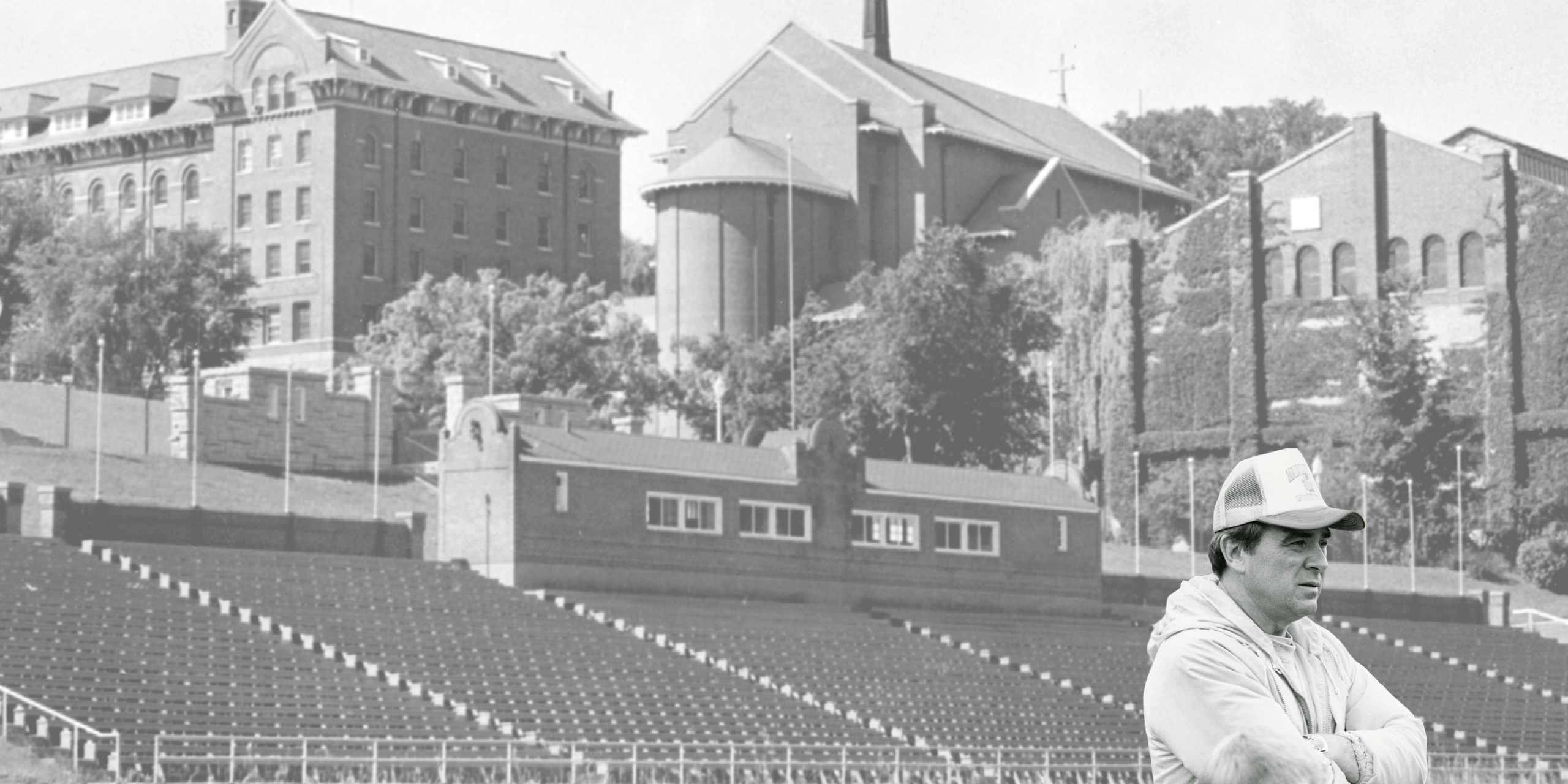 black and white photo of football stadium and church with person standing in front.