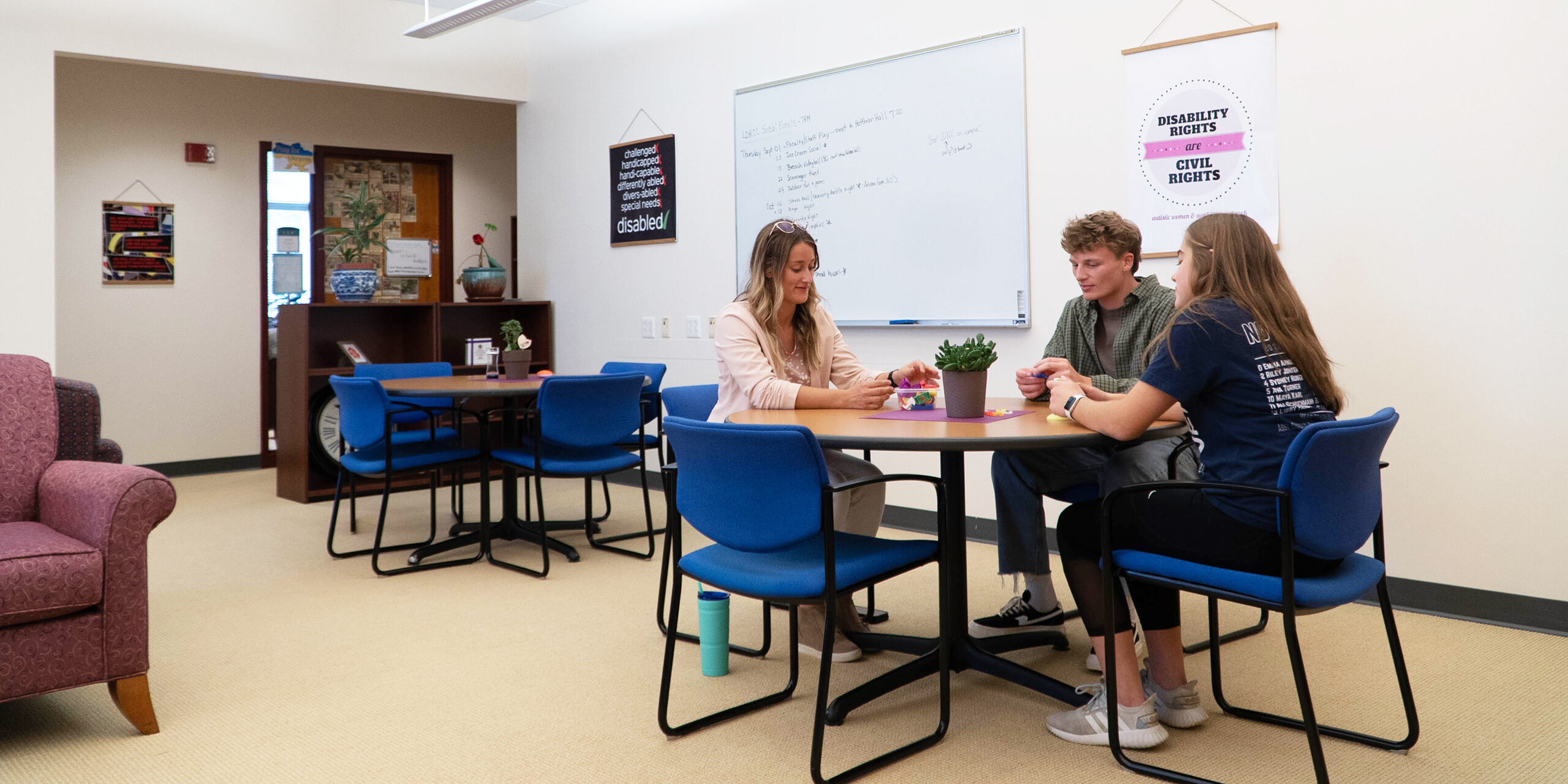 Loras students gathering at table to study in the Loras Lynch Disability and Cultural Center