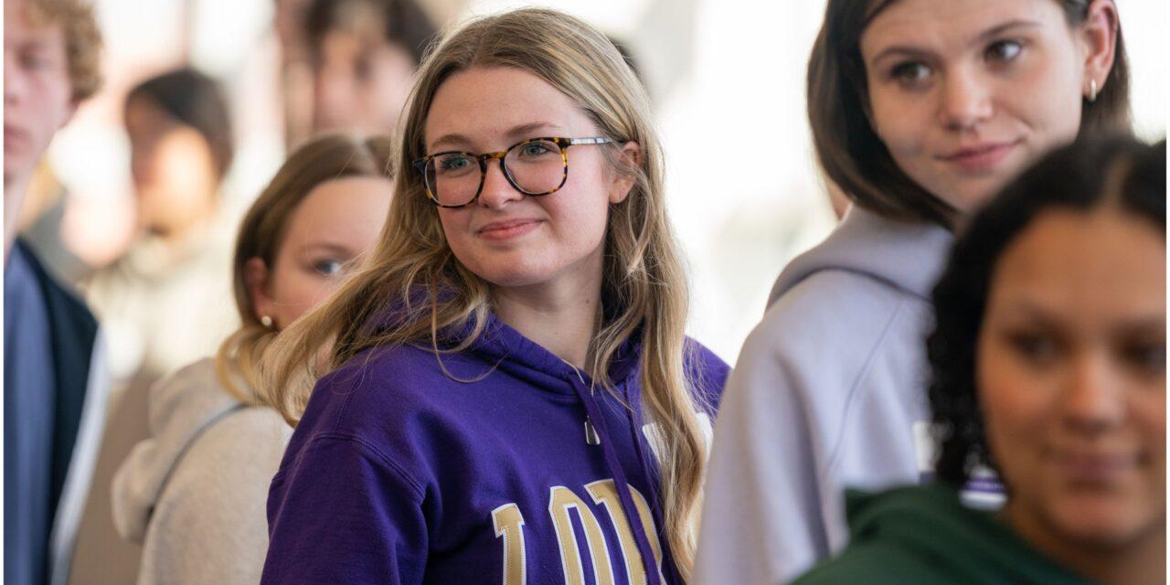 Smiling student in group visit in purple sweatshirt