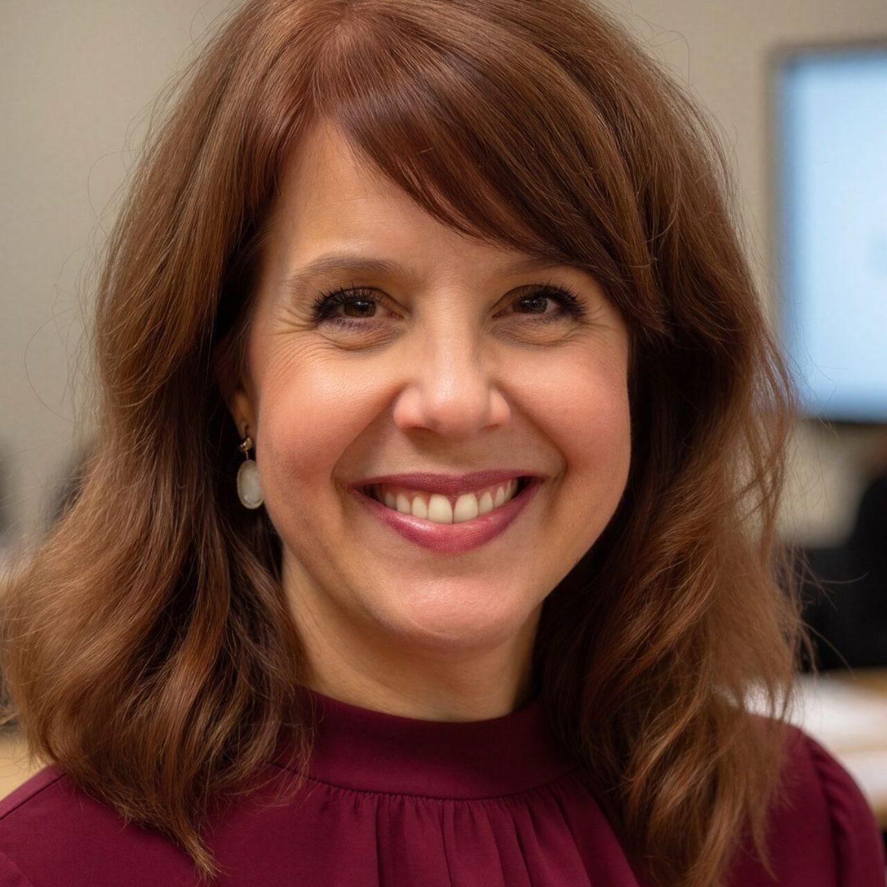 Smiling person with red shirt and brown hair