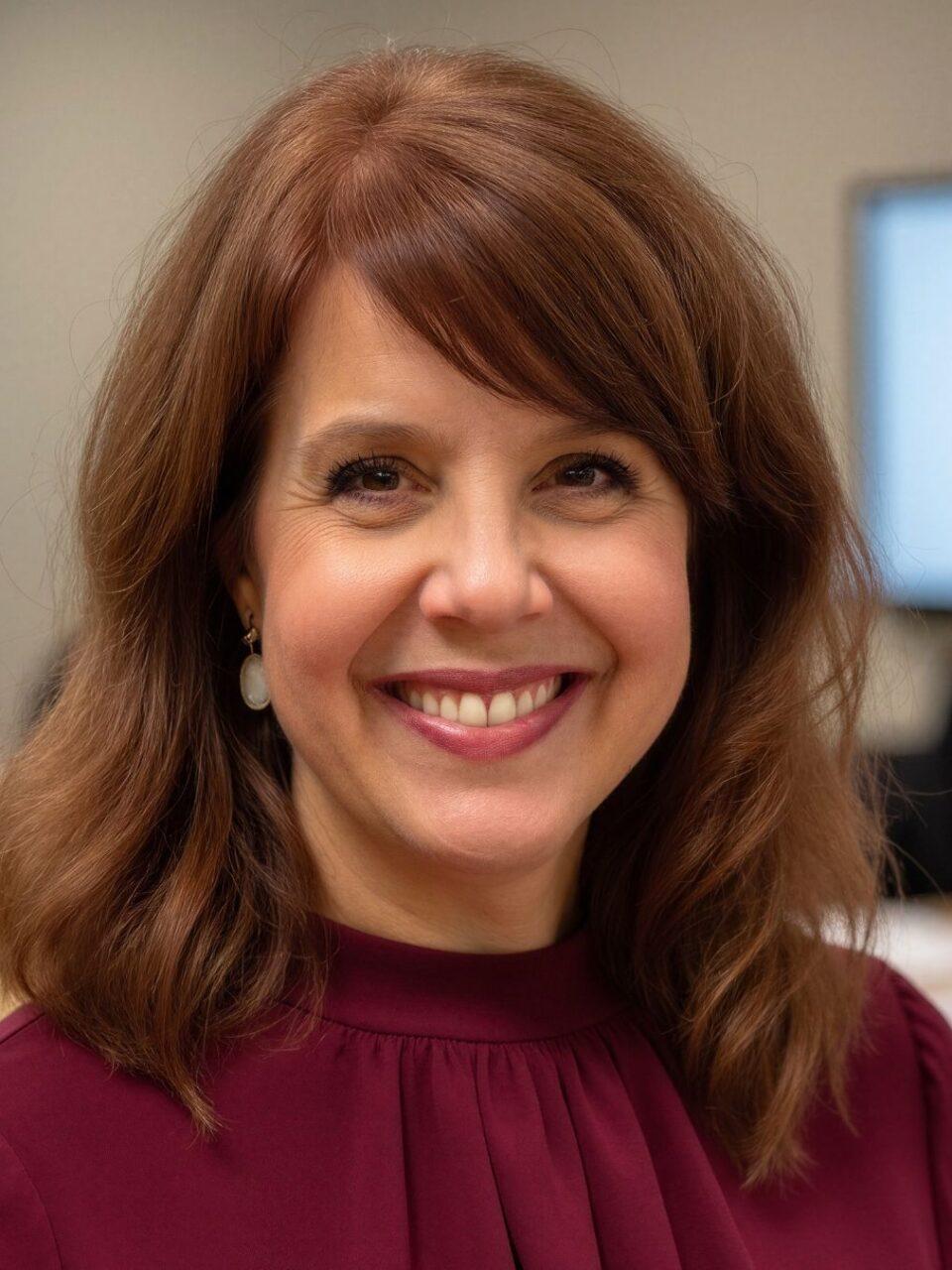 Smiling person with red shirt and brown hair