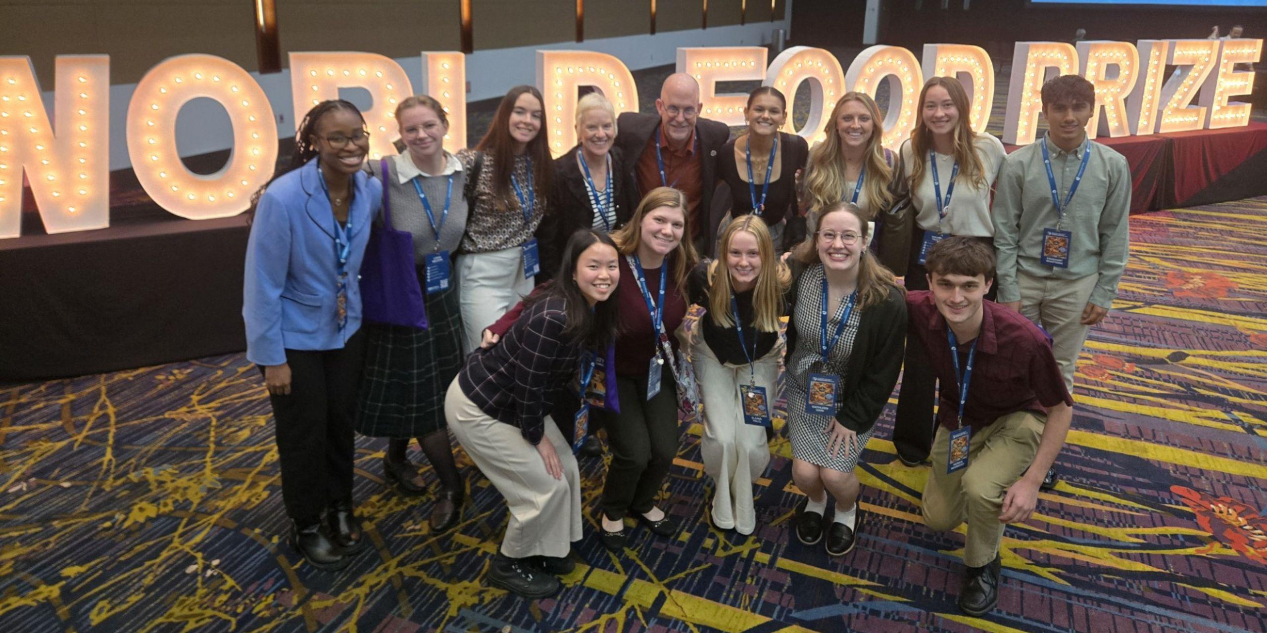 12 Loras students and 2 Loras professors pose at the Norman E. Borlaug International Dialogue