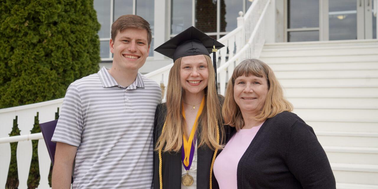 Loras College graduate smiling with family on Commencement Day