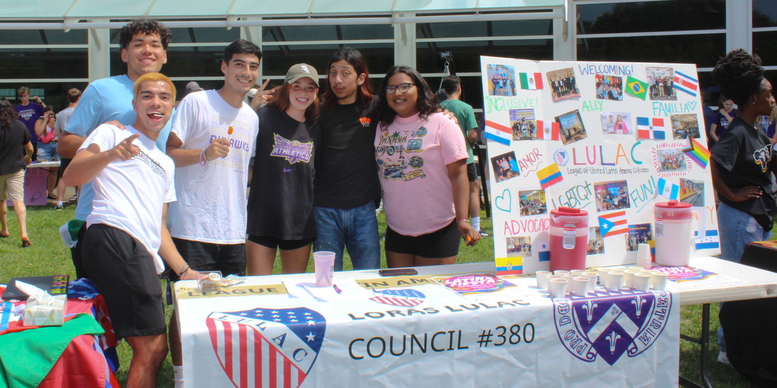 Loras Students standing in front of a table promoting Clubs and Orgs at Campus Fest