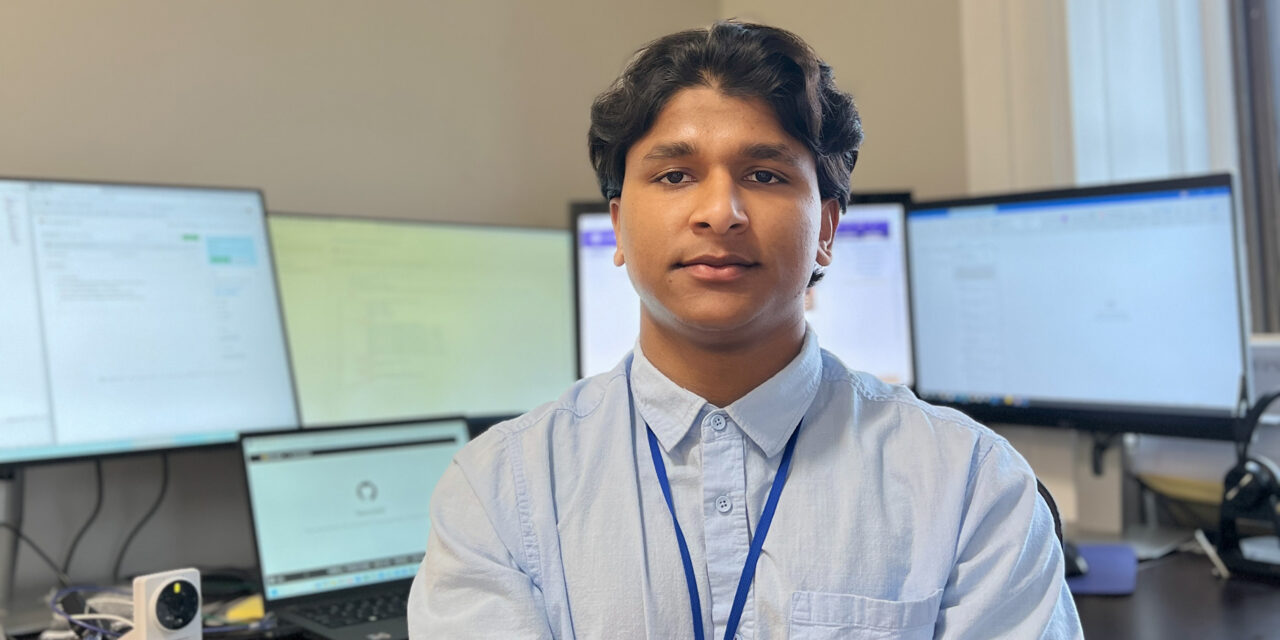 Shree Prakash Shah ('25) sitting at his desk with 4 desktop computers behind him.