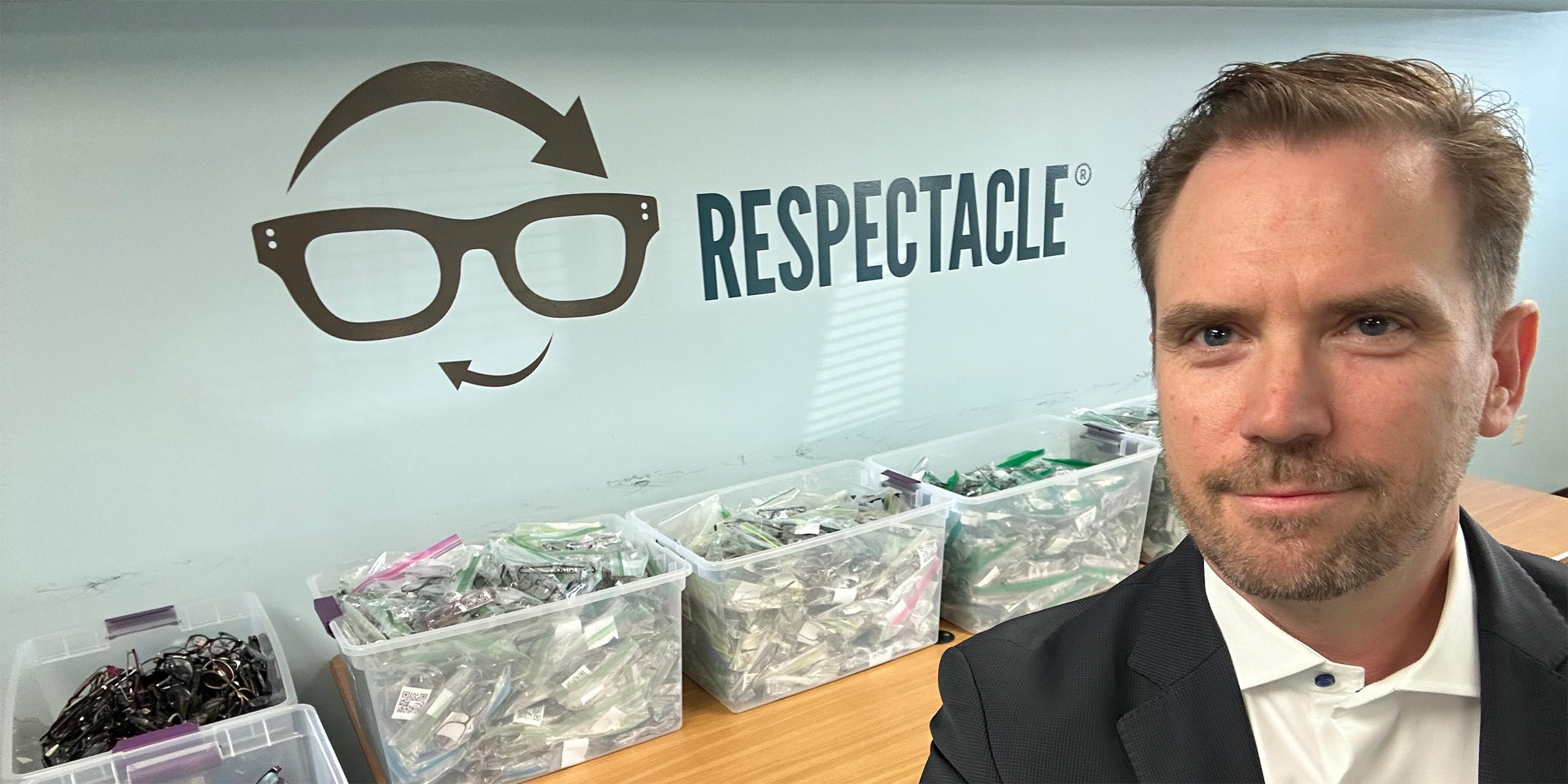 Selfie of man with bins of glasses behind him