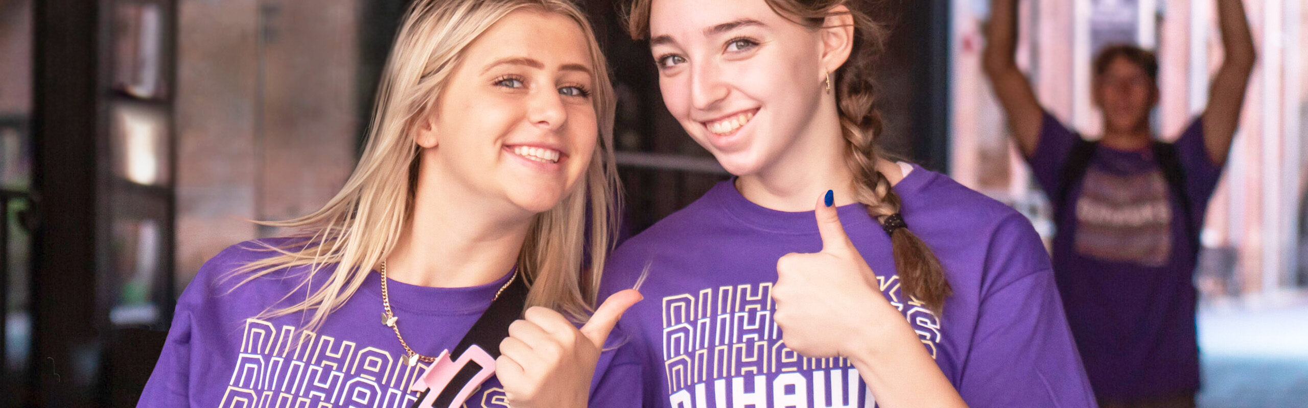 Two Duhawks expressing Duhawk Pride by smiling and giving camera a thumbs up