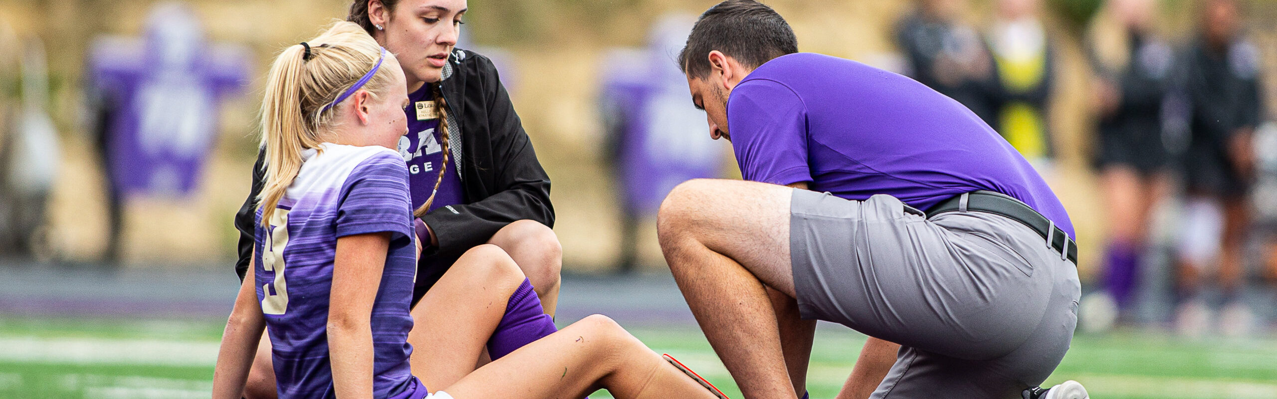 Duhawk Women’s Soccer player receiving assistance on her hurt ankle from Loras Athletic Training students