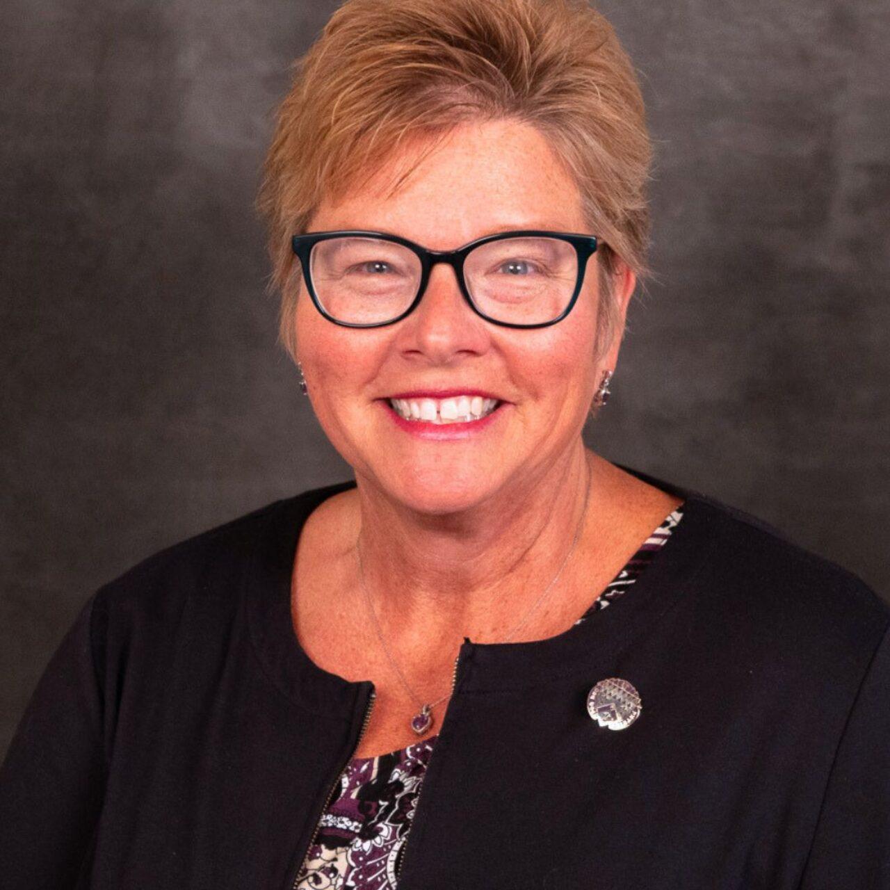 smiling person with short hair and black sweater