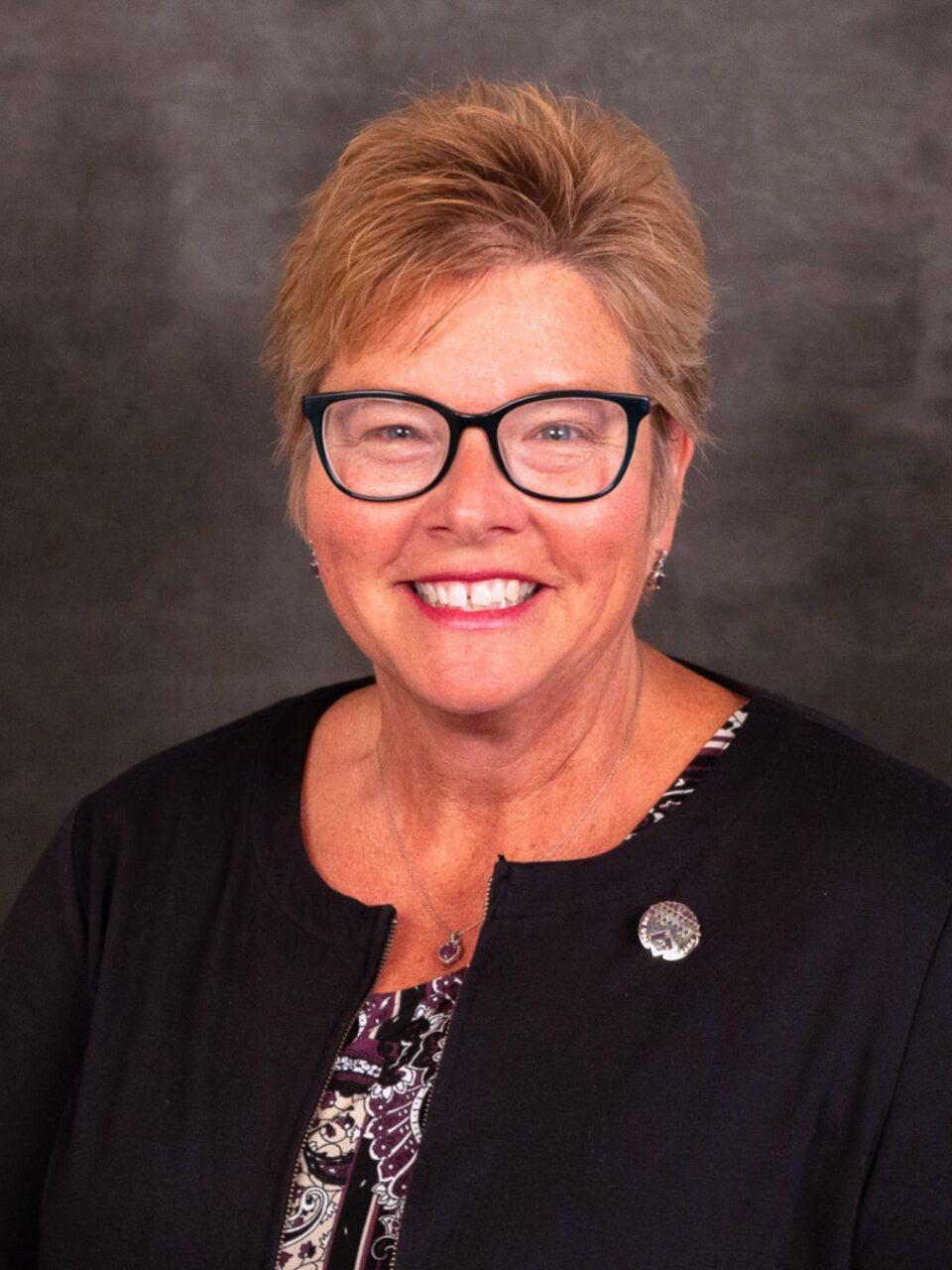 smiling person with short hair and black sweater