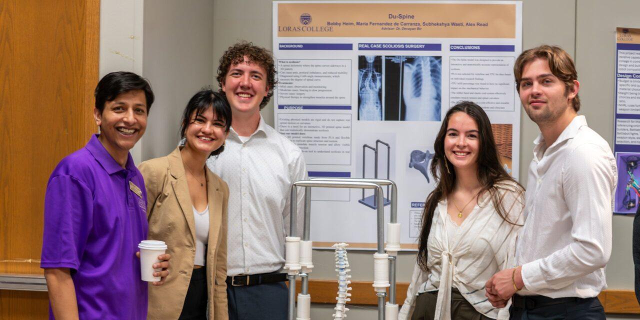 Professor and students posing with engineering project.
