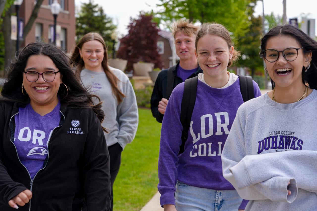 five students walking, smiling. and laughing