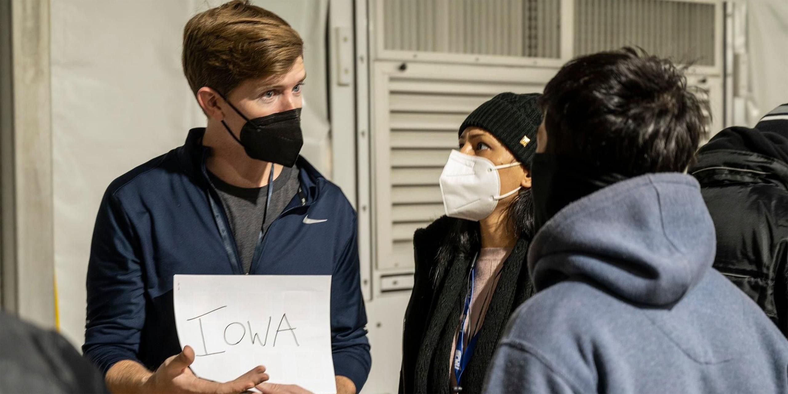 Man holding sign having a conversation with a man and woman