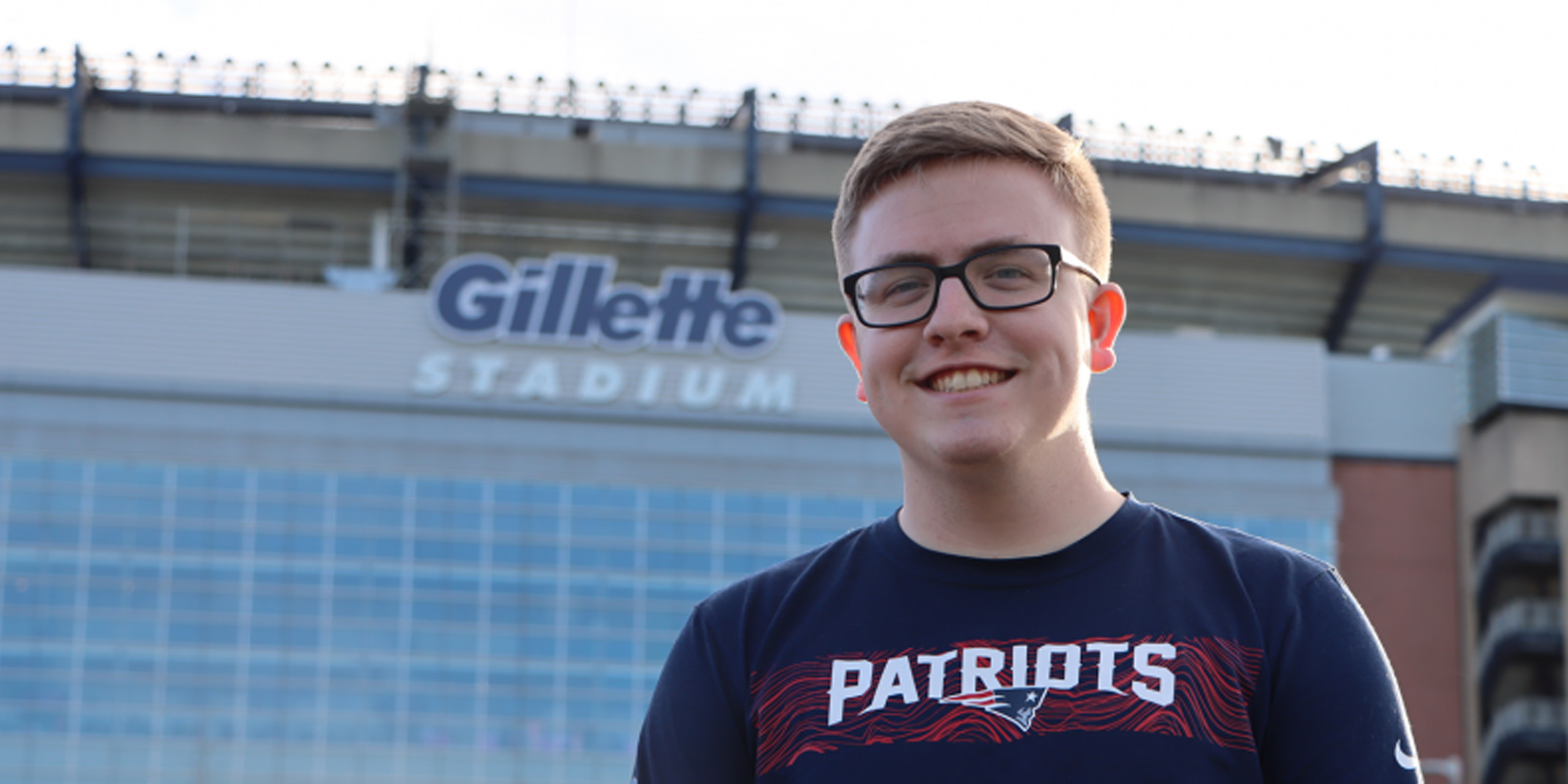 Student standing in front of Gillette Stadium.