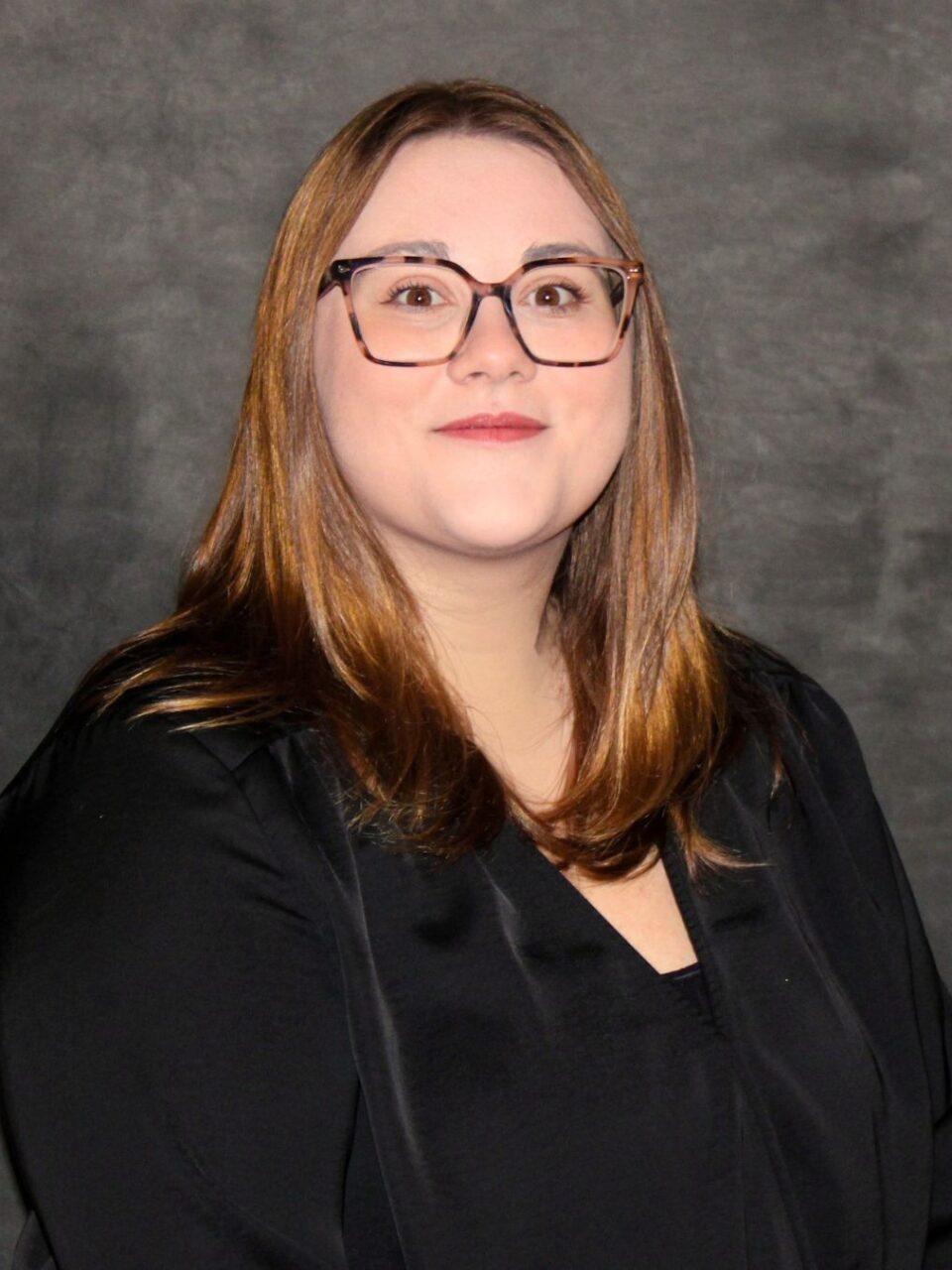smiling Loras employee in black shirt with long hair and glasses