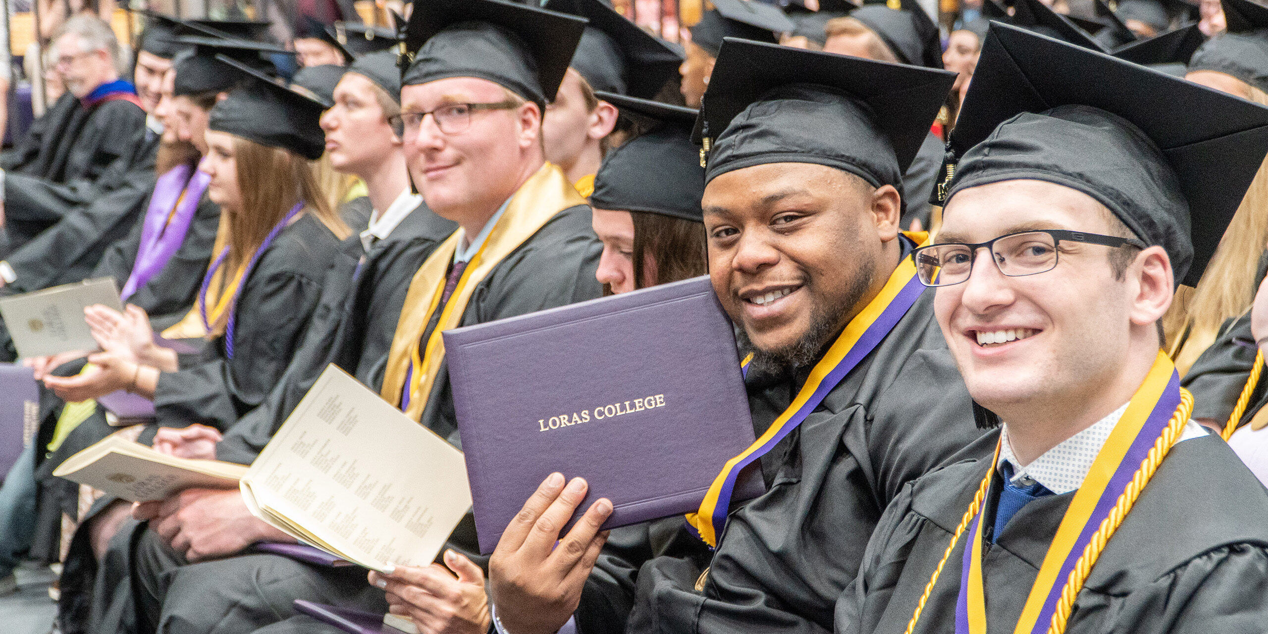group of graduate students with computers sitting around conference table having discussion