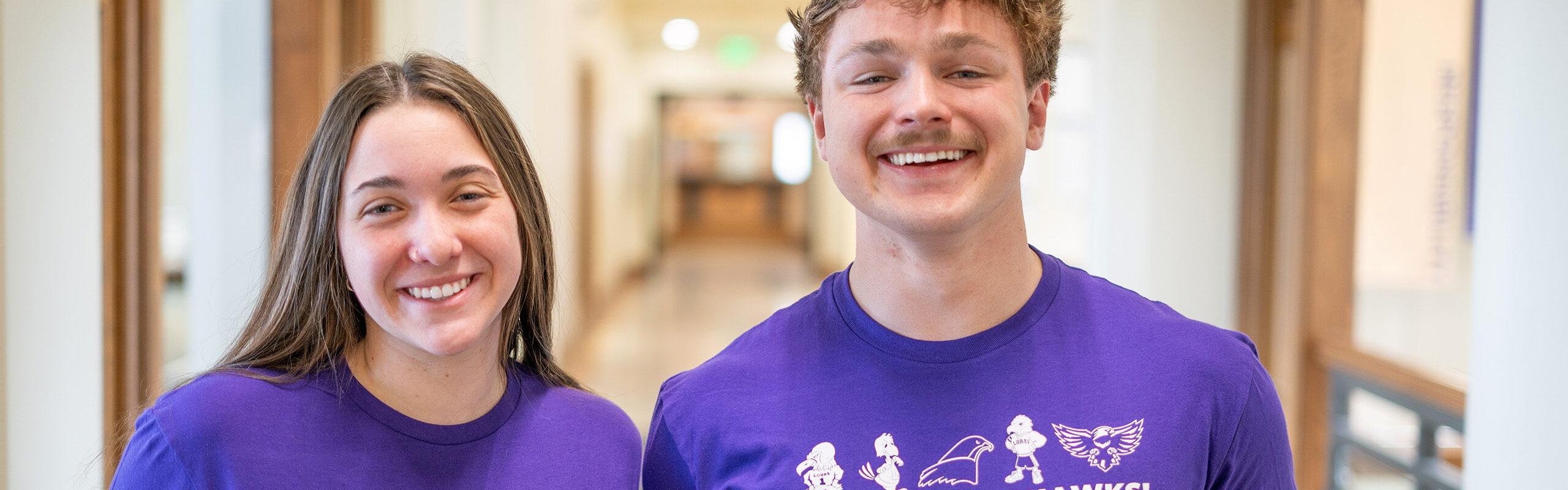 Two Loras students smiling and wearing "Du What? Duhawks!" tshirts