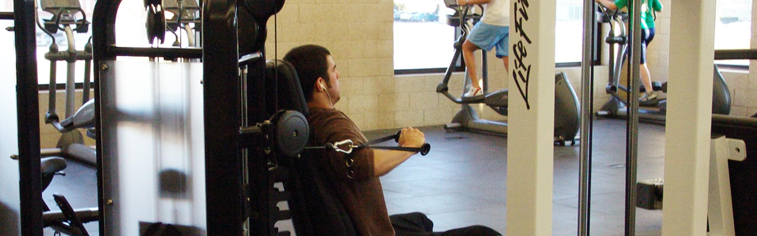 student lifting weights in fitness center