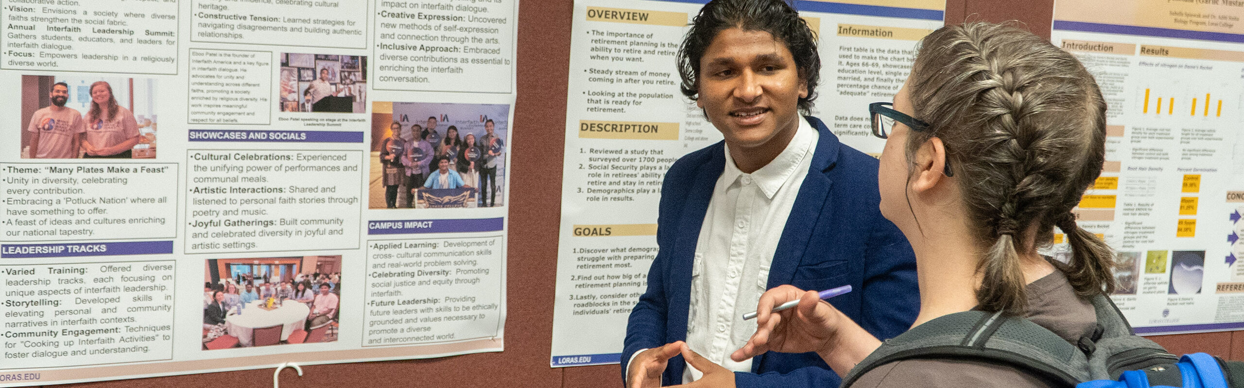 wall of posters with students presenting in front and attendees listening