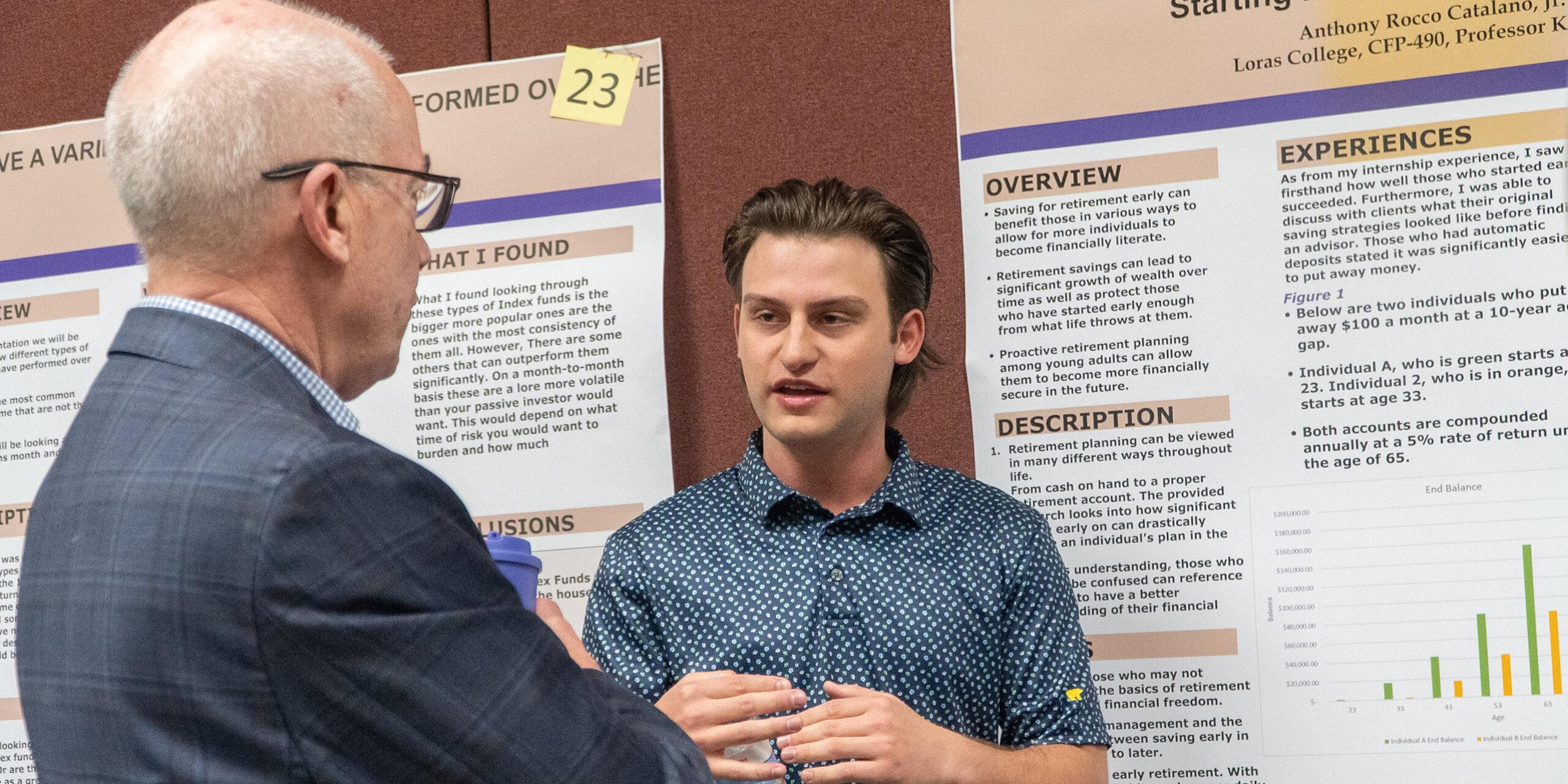 Proud Loras College student discussing research project with Loras President Jim Collins ('84) at the Legacy Symposium in spring