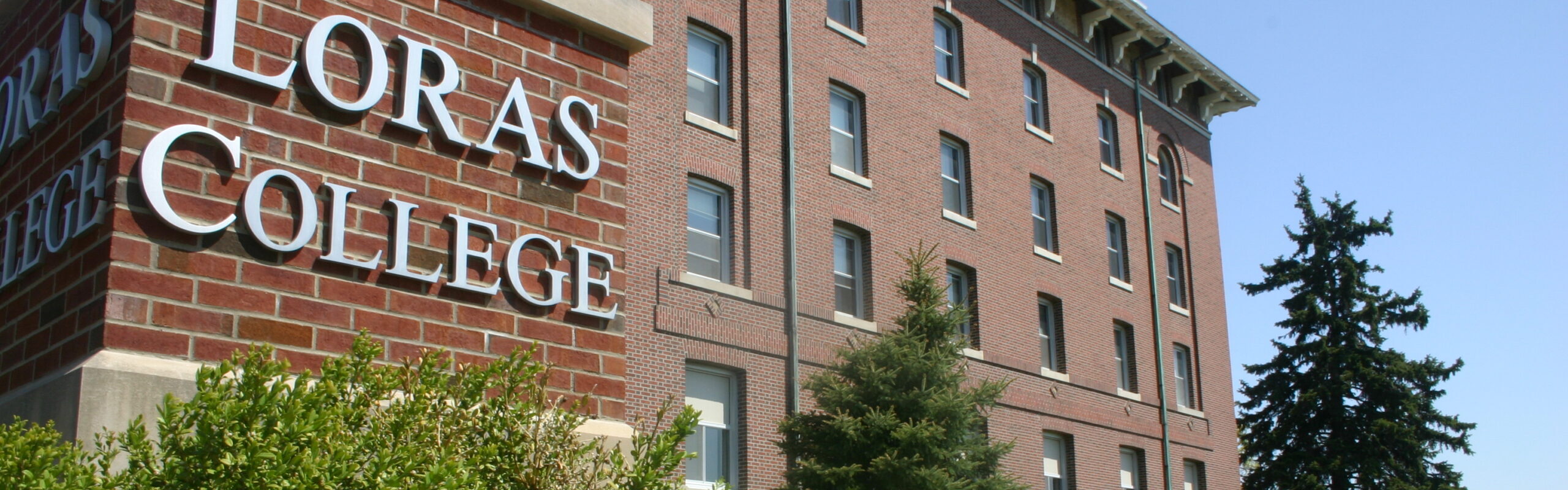 Loras College Pillar Sign with side view of Keane Hall