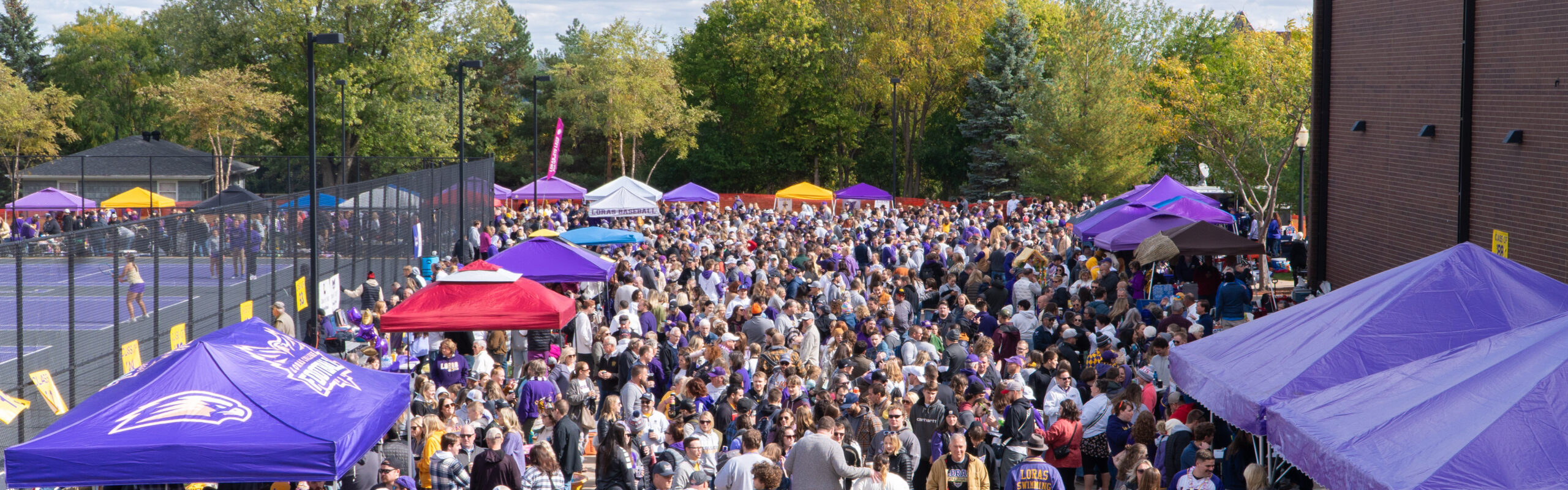 tailgate parking lot filled with homecoming crowd and tents